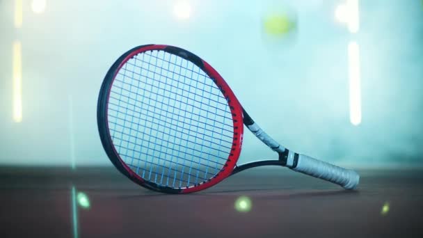Теннисные мячи и ракетка на полу спортзала — стоковое видео