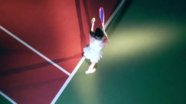Tenis topu servis eden atletik bir kadının üst görüntüsü. — Stok video