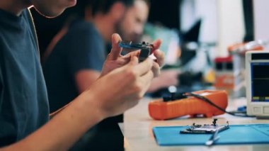 Service technician examining mobile device internals to fix them