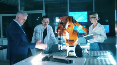 Scientists in a robotic laboratory working with robotic arm.