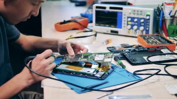 Technician fixing circuit board using electronics repair tools kit — Video Stock