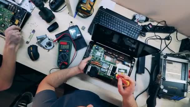 Closeup of gadget specialists fixing electronic devices at workshop — стоковое видео