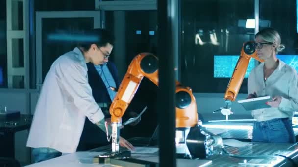 Researchers are working with a robotic device. Engineers teamwork. — Wideo stockowe