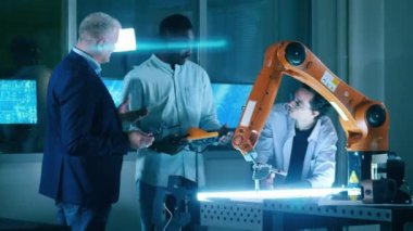 Group of science workers discussing industrial robot. Teamwork concept.