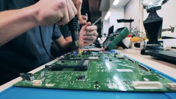 Technician repairing laptop system board using hot air gun — Stock video