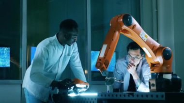 Erkek bilim çalışanları modern bilim laboratuvarında bir robotla çalışıyorlar..