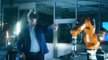 Erkek bilim işçisi modern endüstriyel robotu çalıştırmak için VR-gözlük kullanıyor.