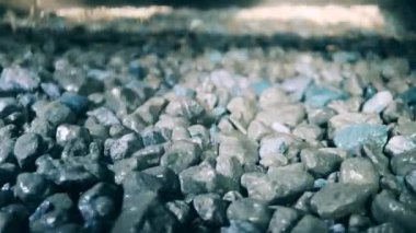 Parçalanmış mineraller taşıyıcı boyunca hareket ederken titriyor.