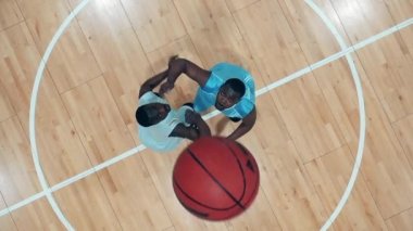 Ağır çekimde basketbol için dövüşen iki oyuncunun üst görüntüsü