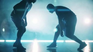 İki Afrikalı Amerikalı oyuncu yavaş çekimde bir basketbol topu için savaşıyor.