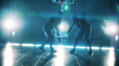 İki Afrikalı Amerikalı yavaş çekimde basketbol oynuyor.