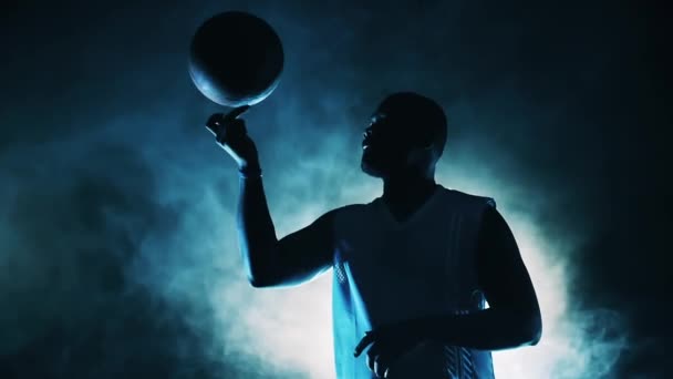Basketballer dreht in Rauchwolken Ball am Finger — Stockvideo