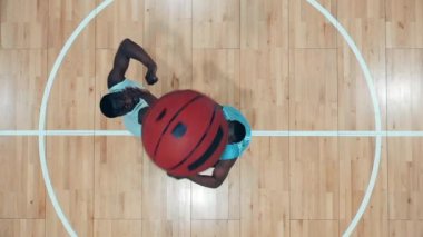 İki Afro-Amerikan oyuncu bir basketbol topunu en üst görüşe taşımaya çalışıyor.