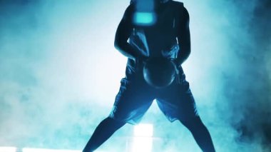 Bir basketbolcunun dumana top atması ağır çekimdir.