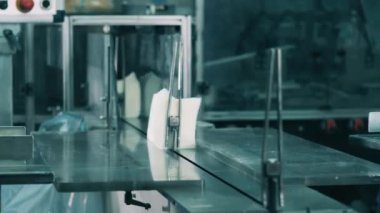 Fabrika işçileri bir taşıyıcıya beyaz yüz dokusu yığını yerleştiriyorlar.