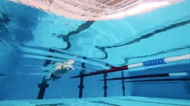 Sporcu kelebek yüzer. Su altı çekimi.