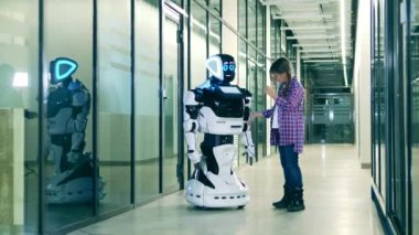 Küçük kız gelecekçi bir robotla konuşuyor. Robot bilimi, teknoloji, yenilik kavramı.