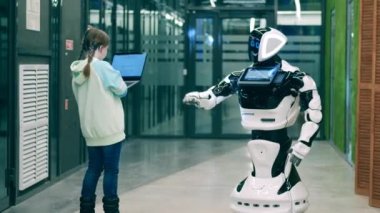 Çocuk dizüstü bilgisayarı olan sibernetik bir robot kullanıyor.