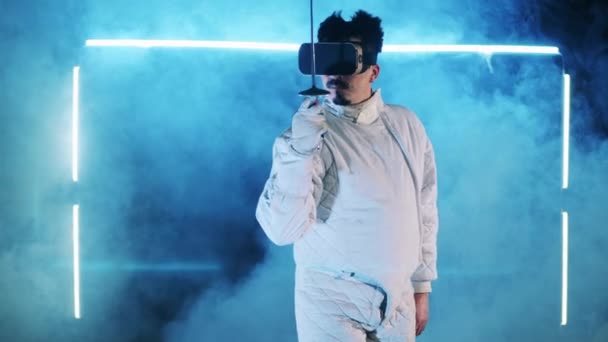 Mannelijke omheining gebruikt een VR-apparaat tijdens de training. Virtual reality, augmented reality game concept. — Stockvideo
