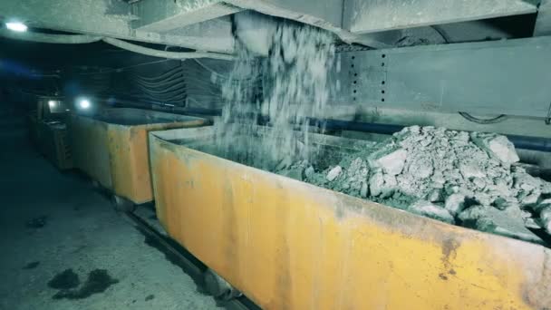 Underjordiska gruvor med söndersmulad malm som faller i containrar — Stockvideo