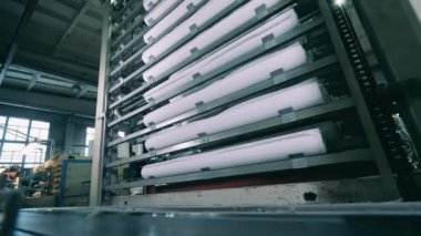 Uzun beyaz kağıt ruloları otomatik olarak makineye yerleştiriliyor