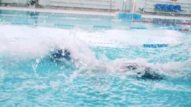 Ağır çekimde kurbağalama yüzen bir adamın yan görüntüsü