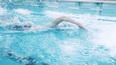 Havuz şeridini kurbağalama yüzücüsü geçiyor.