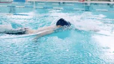 Havuz şeridi boyunca yürüyen bir yüzücünün yavaş hareketi
