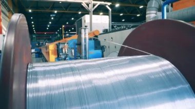 Kalın gümüş tel büyük bir makaradan sökülüyor