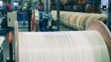 Beyaz güç kablosu büyük bir makaradan kopuyor.