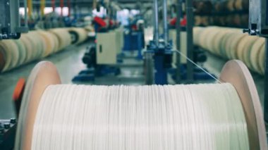 Büyük bir makaradan çıkan kalın beyaz kablo.