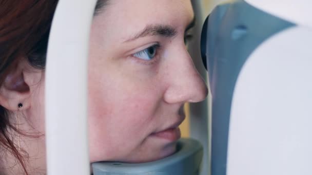 Una señora está revisando su vista con una máquina. — Vídeos de Stock