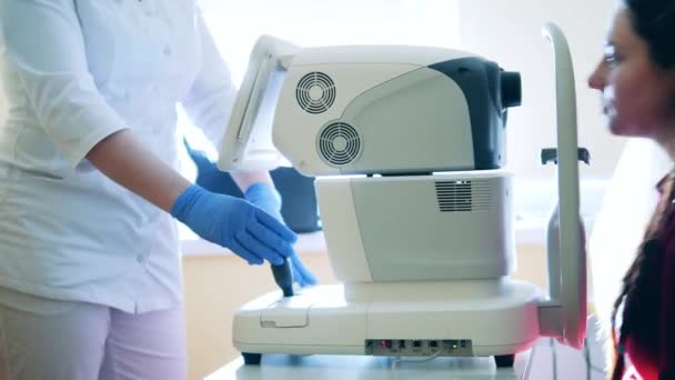 Le docteur utilise une machine médicale pour vérifier les yeux des femmes — Video