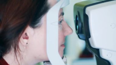 Bir bayan göz kontrol makinesine bakıyor.