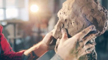 Kil heykel erkek bir sanatçı tarafından şekillendiriliyor.