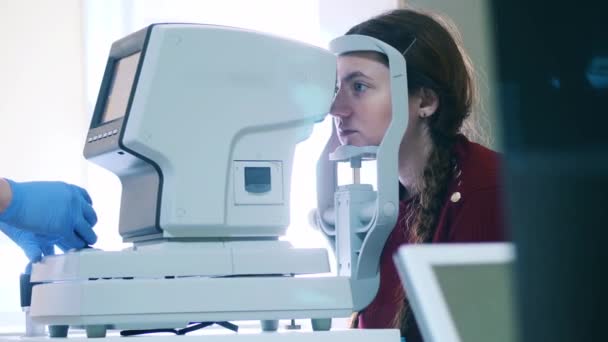 El doctor está inspeccionando los ojos de las mujeres con una máquina médica — Vídeo de stock