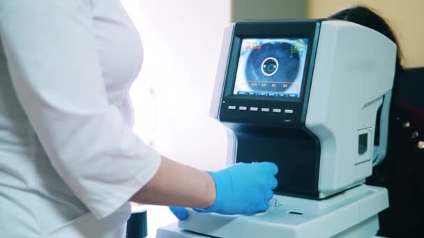 El doctor está operando una máquina de inspección de ojos. — Vídeos de Stock