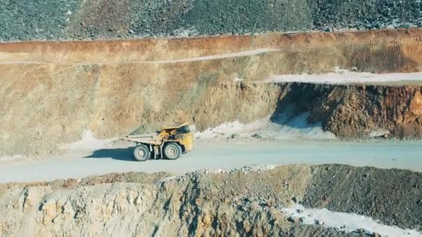 Cantera, minería a cielo abierto, concepto de extracción de mineral. Camión cargado está cabalgando a lo largo de las laderas de una mina a cielo abierto — Vídeo de stock