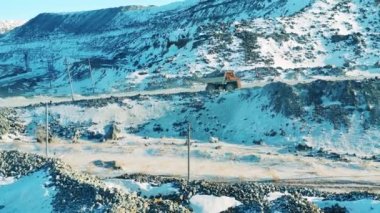 Yüklü kamyon yol boyunca açık çukurda ilerliyor. Taş ocağı, açık maden, maden çıkarma konsepti..