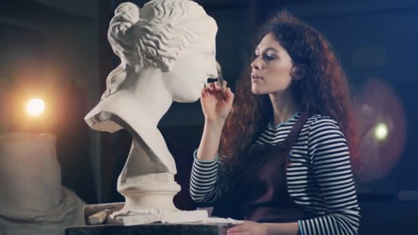 Kobieta artystka używa pędzla do pracy nad rzeźbą gipsową — Wideo stockowe