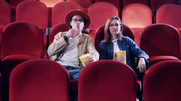 Homem e mulher comendo pipocas no cinema — Vídeo de Stock