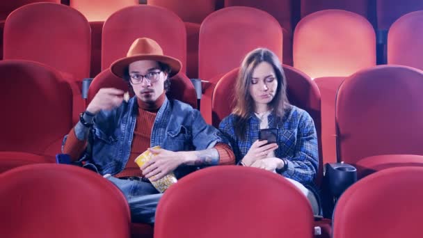 Un paio si annoiano al cinema. Guardare film, trascorrere del tempo concetto. — Video Stock