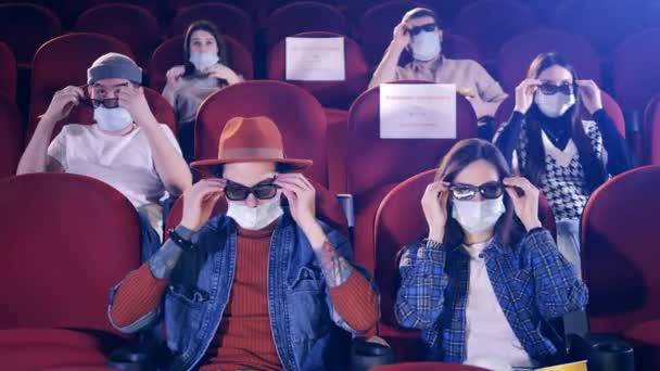Widzowie w maskach do twarzy zakładają okulary 3D — Wideo stockowe