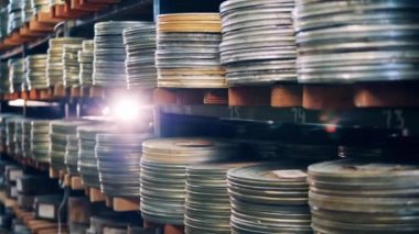 Raflarda film kasetleri olan eski metal kutular.