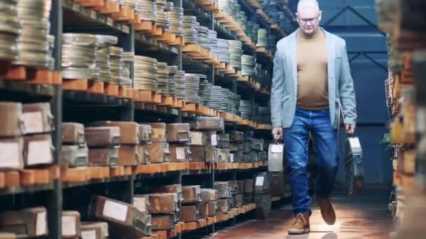 Archivspezialist trägt massive Koffer mit Filmbändern — Stockvideo
