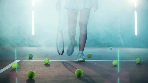 Bayan oyuncu tenis kortunda yürüyor.