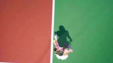 Bayan tenisçi sahada en üst düzeyde antrenman yapıyor.