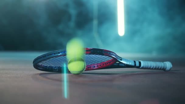 Теннисные мячи падают на пол рядом с ракеткой — стоковое видео