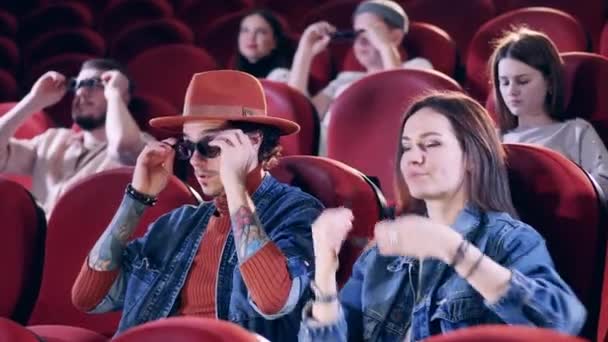 A ver filmes, a passar o tempo. As pessoas põem óculos no cinema — Vídeo de Stock