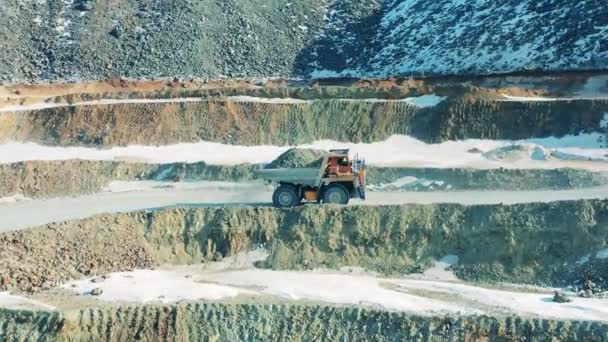 Truck loaded with ore is driving through the mine site. Industrial quarry, heavy industrial machinery working at the mining open pit. — Stock Video